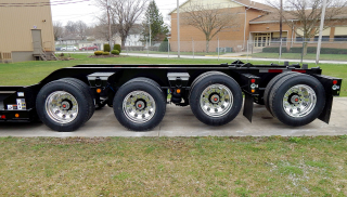 Wide trunnions between the tires provide additional load space on the trailer's rear frame.

The 3rd and 4th axles are shown in the lifted position using the axle air lift on each.

Polished aluminum disc wheels (outer only - steel inner) are optional equipment that reduces weight while enhancing the appearance of the trailer.

Optional LED amber marker/clearance lights are mounted below each trunnion. 

The toggle switch for the optional LED oval amber strobe lights is located on the side of each rear channel - on the rear frame and on the removable/flip axle.