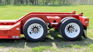 Sloped 30° bridge ramps give easy loading access to the rear frame of the trailer.  Wide trunnion outriggers between the tires provide a strong, stable loading position for various machines.