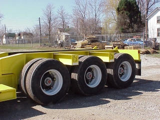 The rear frame is equipped with a severe-duty tri-axle spring/walking beam suspension and spoke type wheels.

The large outriggers have lashing D's on each end for securing tie downs.