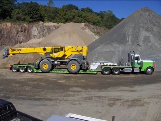 The same Rogers® 55-ton trailer hauls a Cat rubber-tire loader and a Grove rough terrain crane, plus many other pieces of heavy equipment for Stone Industries.