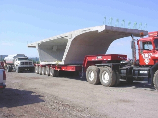 Twin bridges being constructed over the Susquehanna River at Harrisburg, PA.  ROGERS® 100-ton capacity Specialized trailer built to haul precast bridge segments.